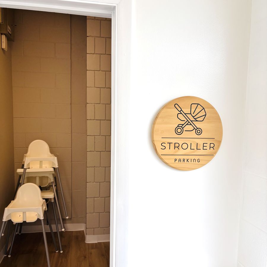 The stroller parking nook, marked with a round wooden Stroller Parking sign.